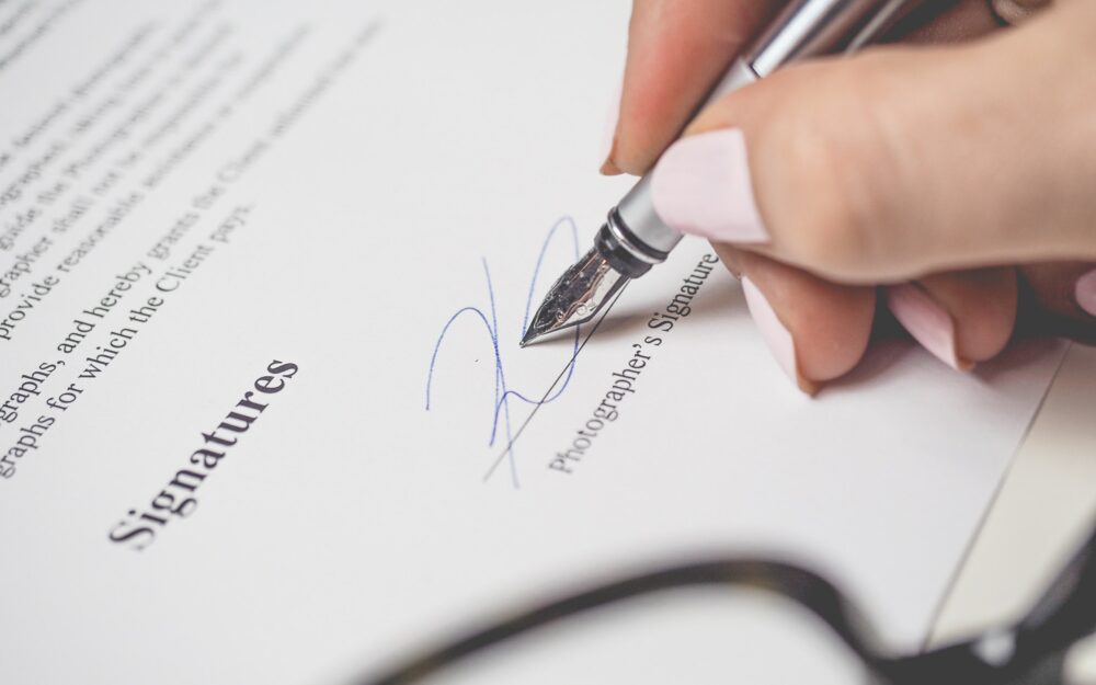 person holding silver pen signing photographers signature 175045